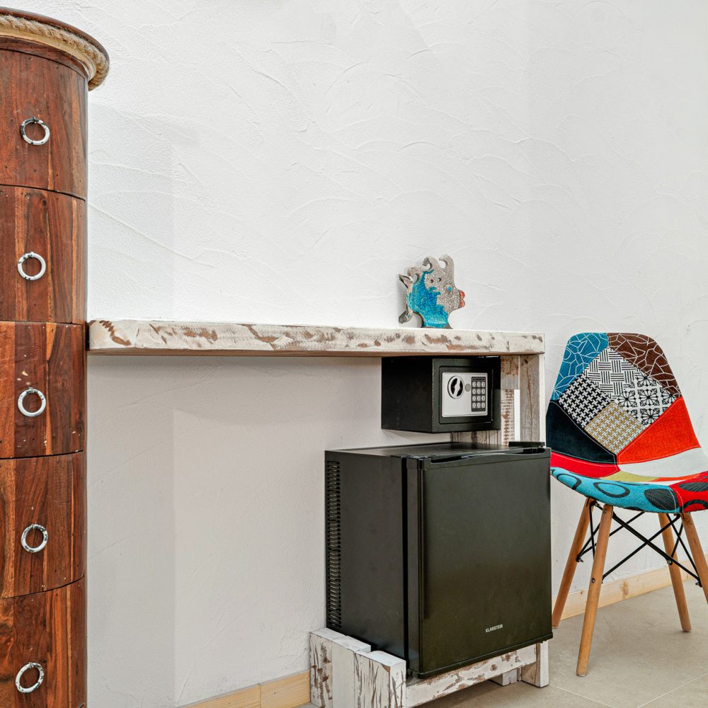 La scrivania con la cassaforte e il frigobar della camera in affitto a Olbia Chiattino della casa vacanze Liboa House